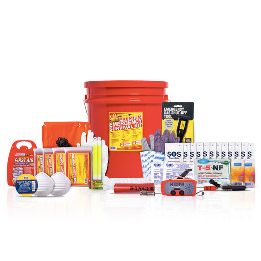 A comprehensive emergency survival kit arranged on a white background, featuring a large red bucket, food bars, water pouches, first aid kit, masks, and various other survival and safety items.